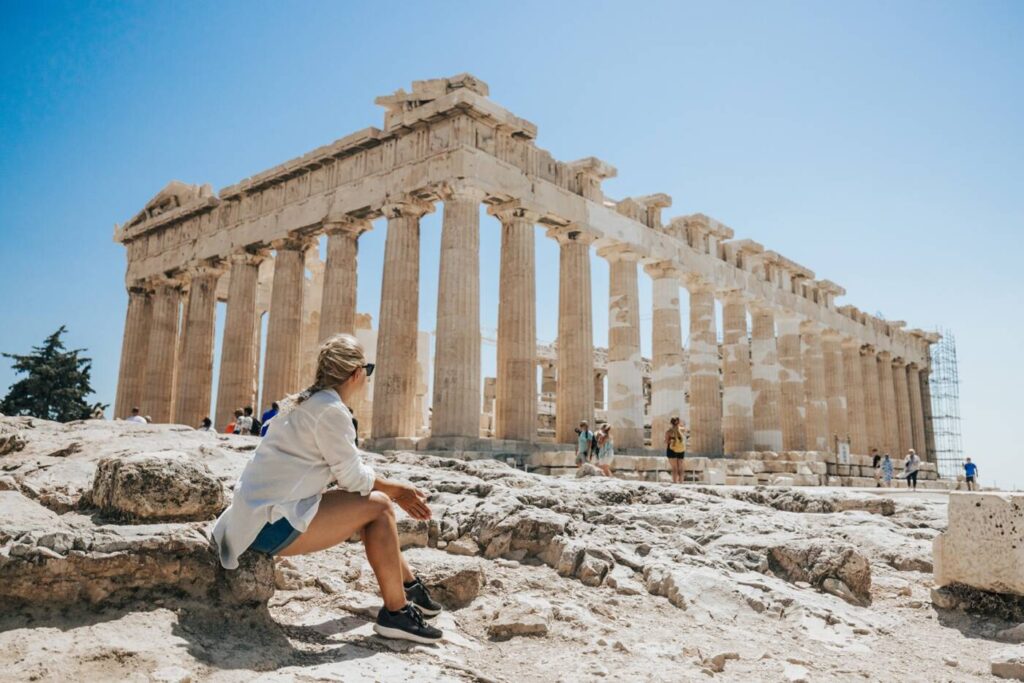 A woman at the Acropolis during the day while on a women's group tour of Greece