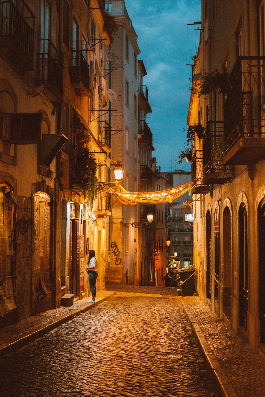 A photo of a Portuguese city alley way light up at dusk