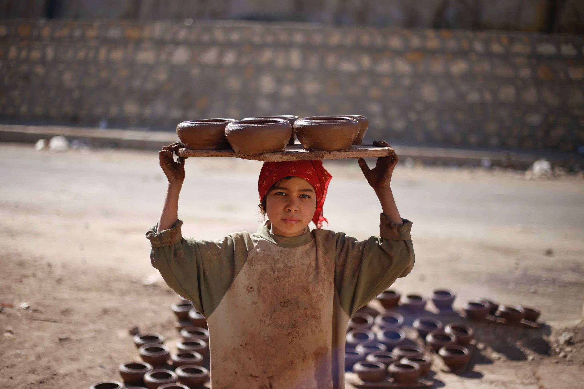 A woman carrying a tray on her head of bowls in Egypt