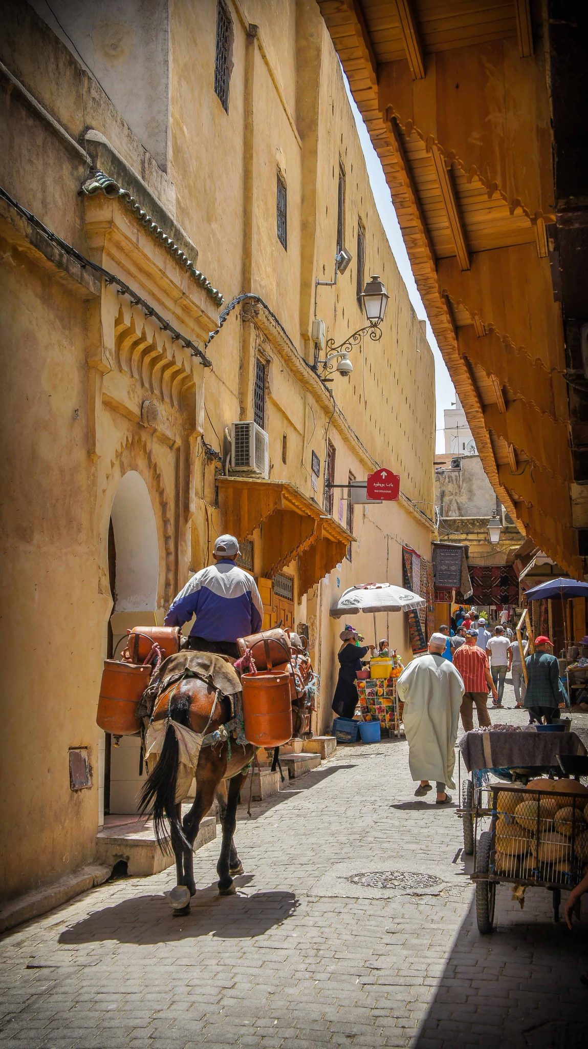 A Moroccan city alley way full of people and life on a Womens Travel Network Morocco Tour For Women