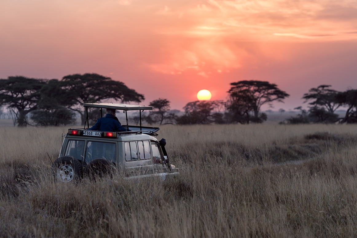 Sunset over the kenyan grass lands with a safari 4x4 in the photo during WTN's Kenya Safari for women